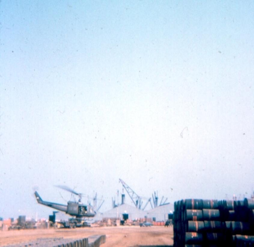 Chopper Taking Off From Satging Area Behind Warehouses At The  Docks - Look At All Those Agent Orange Barrels 