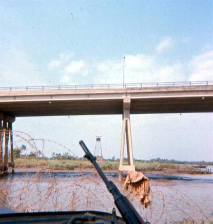 February 2, 1968 - Photo Taken From APC Position West Of Maintenance Building - The Discoloration On Right Side Of Concrete  Railing Wall Of Bridge Is From Newport Personnel Firing At The VC - This View Gives You A Good Idea Where The VC Were When The  Exchange Of Fire Began. Tu Duc Cemetery Off Highway #1 - This Is Where The VC Stockpiled Weapons In Graves In Preparation For TET